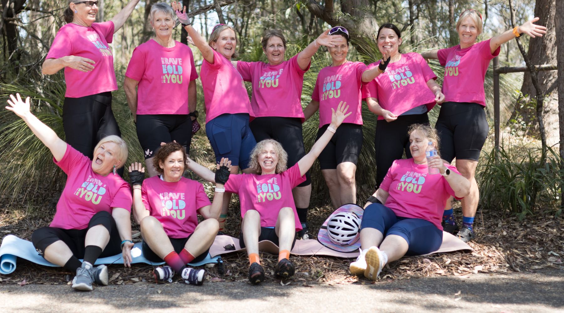 a group of female cyclists in pink tshirts Be Bold Be Brave Be you
