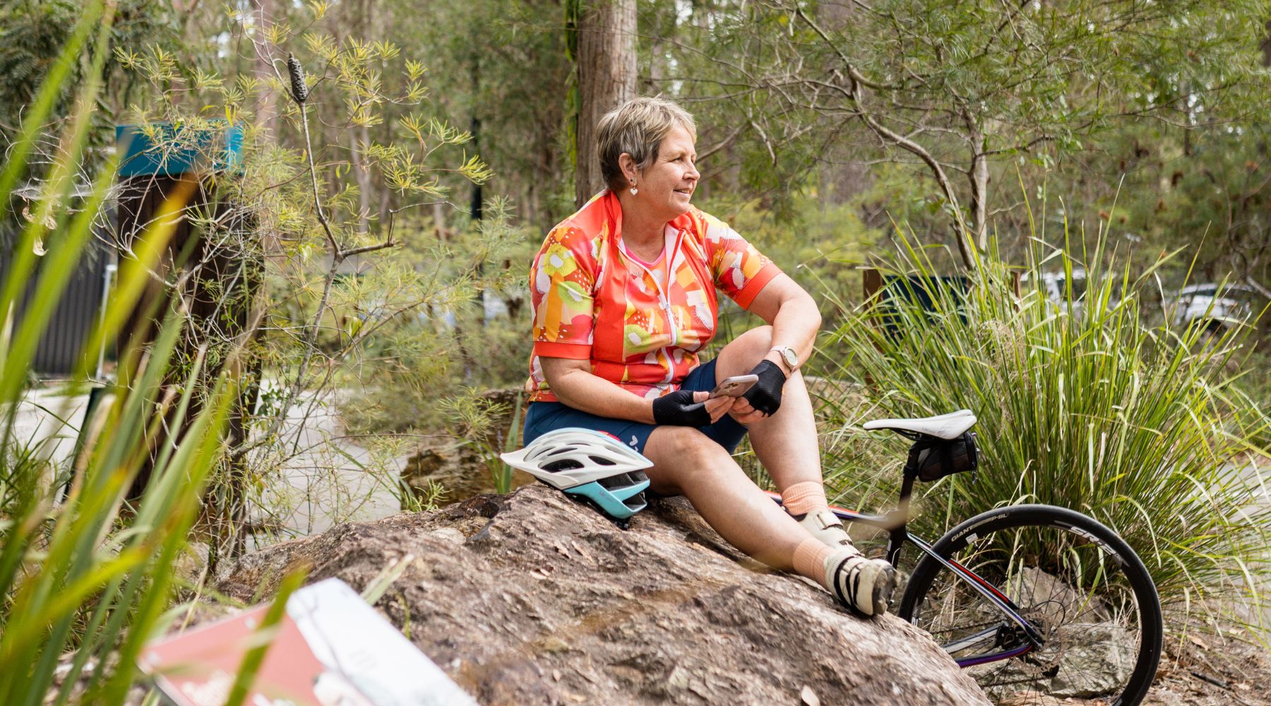 cyclists in colourful jersey sitting on a rock