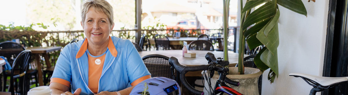 female cyclist in a blue jersey sitting in a coffe shop