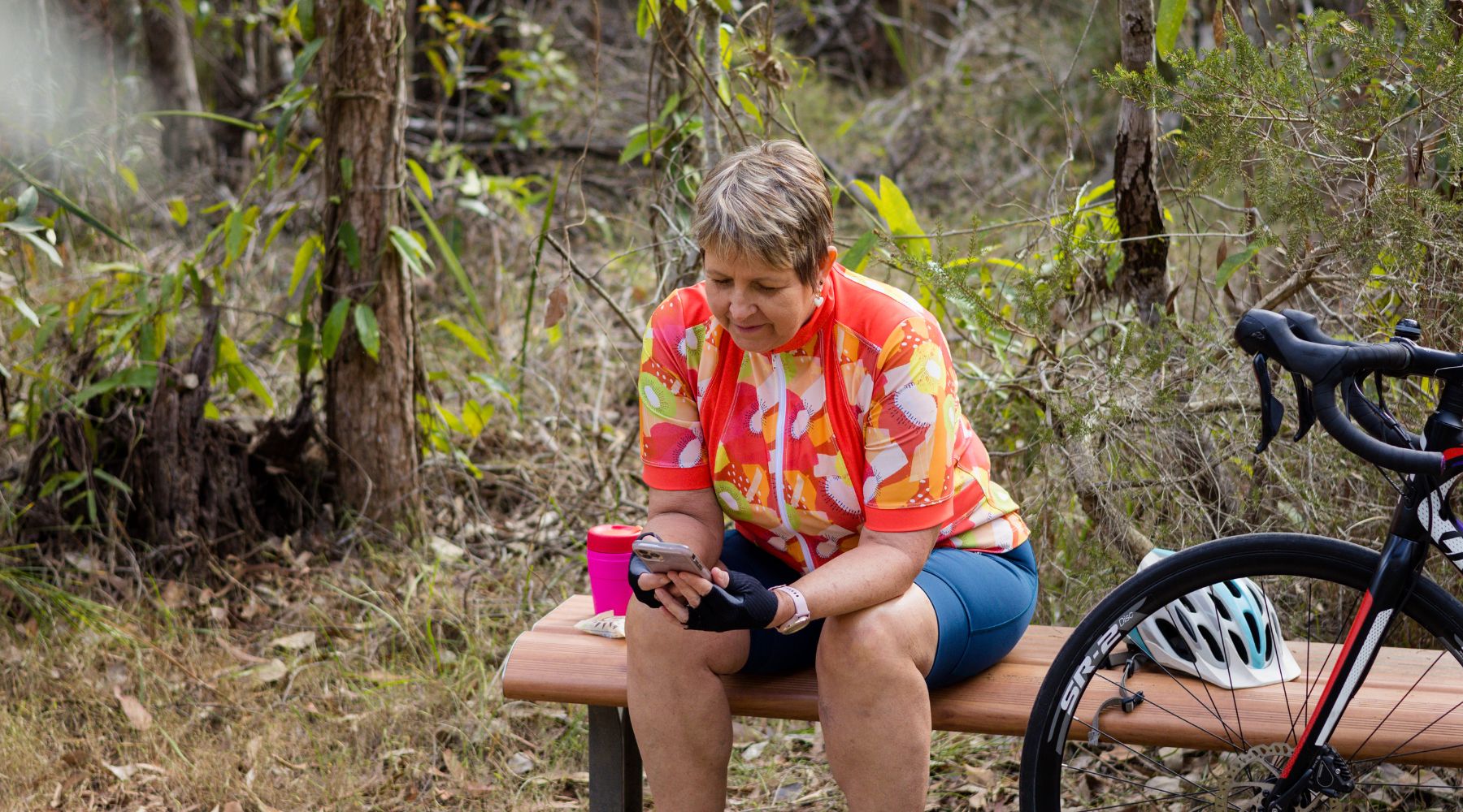 female cyclist resting on a bench