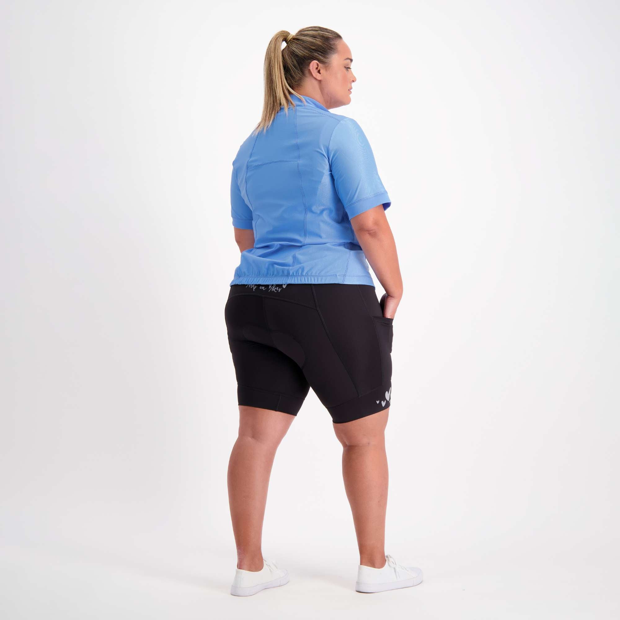 full body back view of female model dressed in blue short sleeve cycling jersey