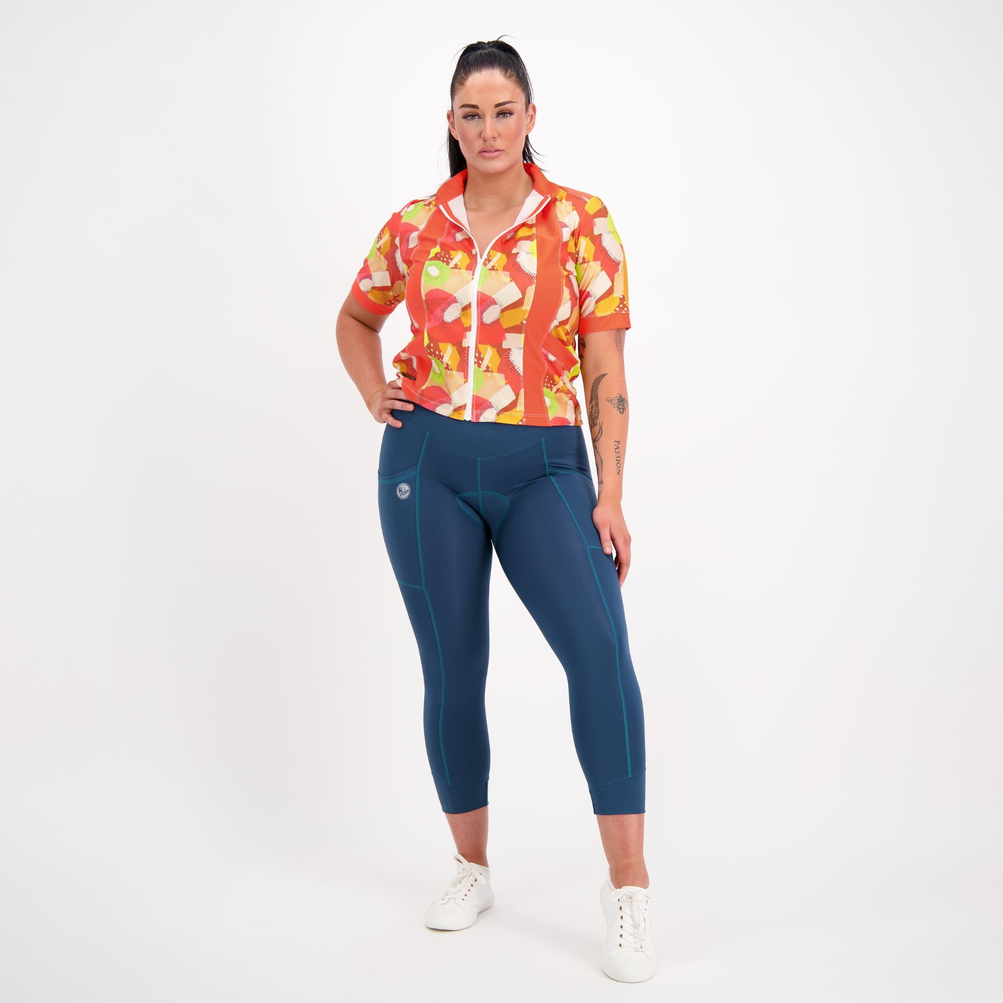 full body view of model wearing Carefree Cycling Jersey in Tutti Fruity orange print