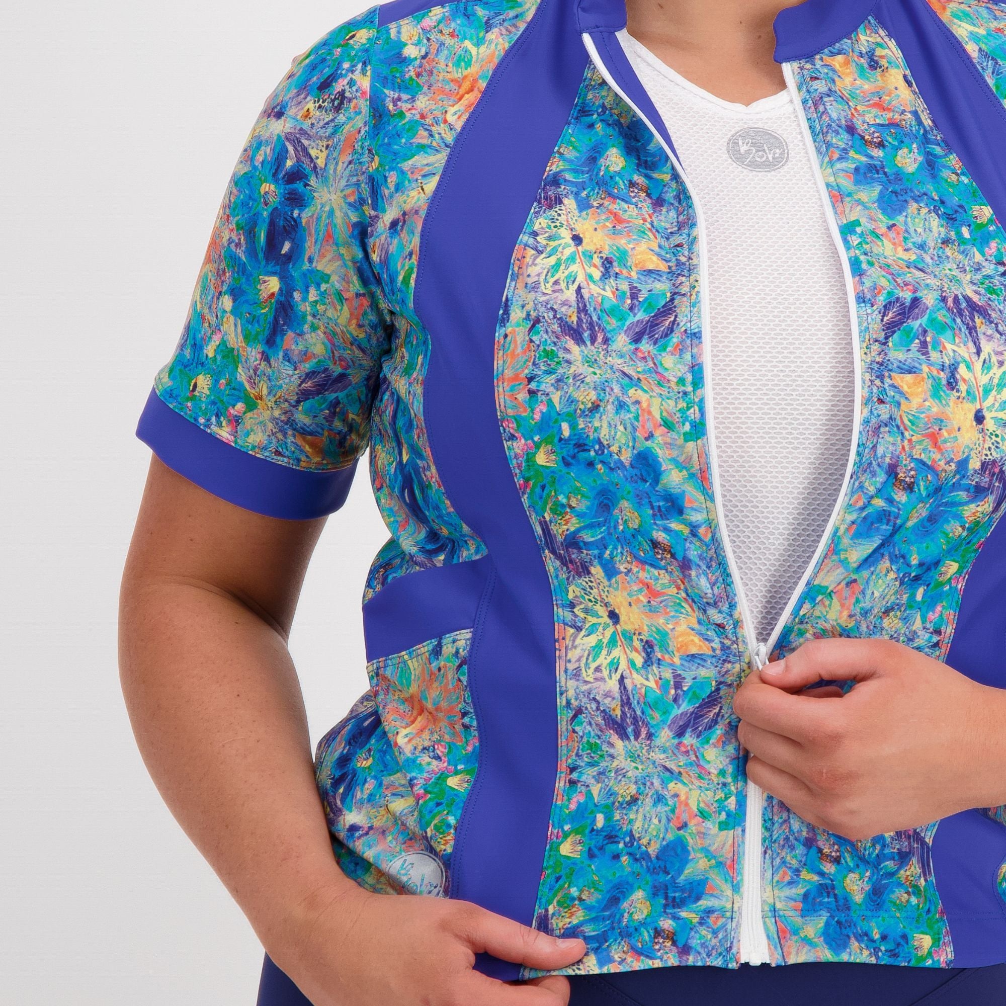 Close up view of zip and panel features on the blue artsy floral carefree cycling jersey