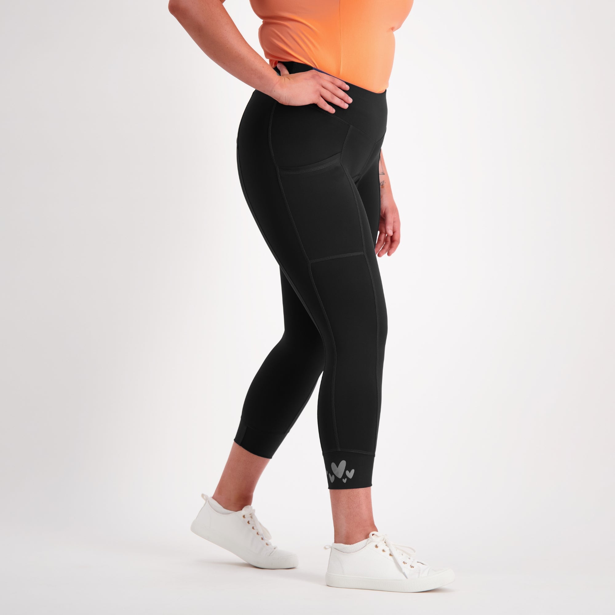 Person wearing black capri padded bike pants on a white background