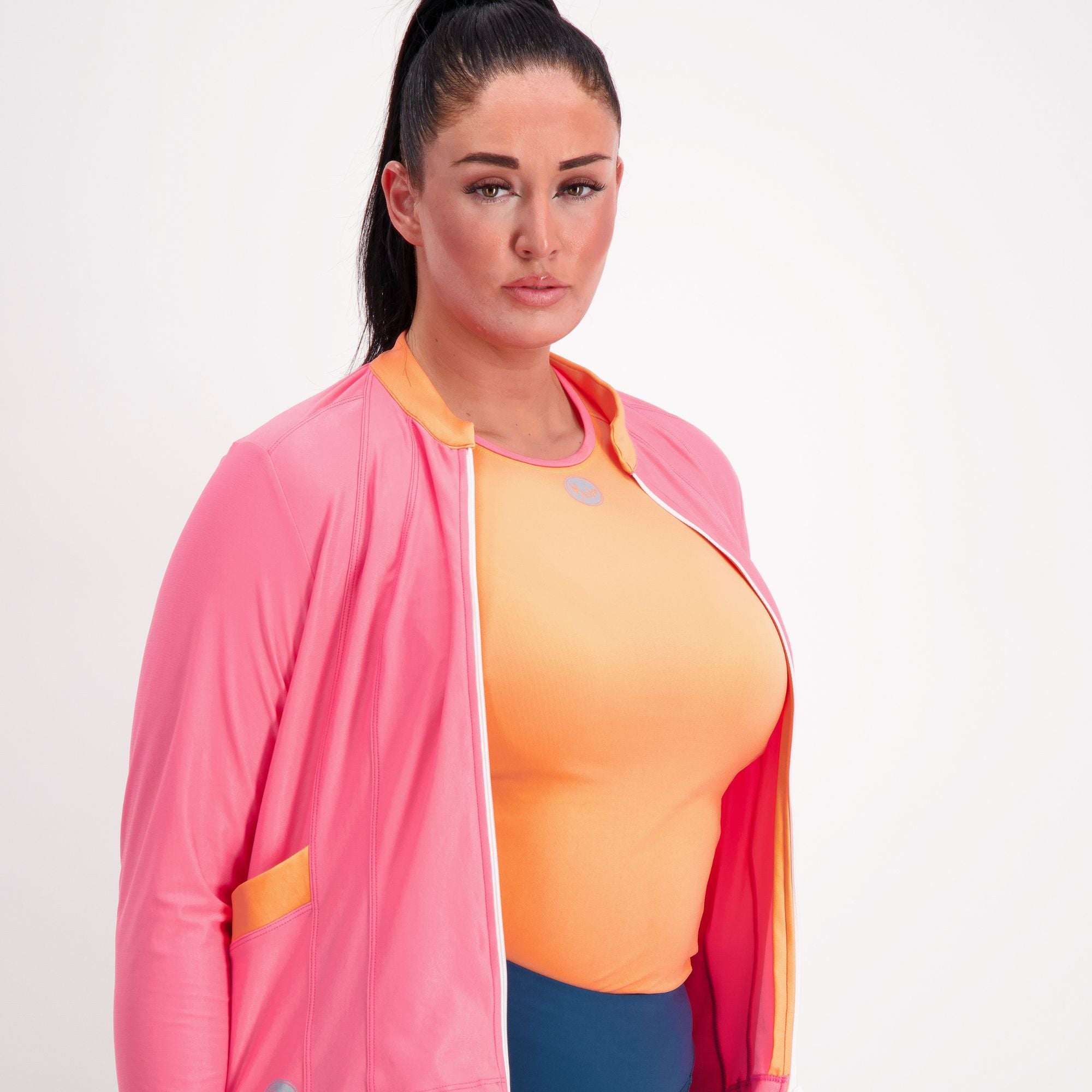closeup of Orange with pink trim sleeveless Cycling Base Layer on female model with a pink jersey