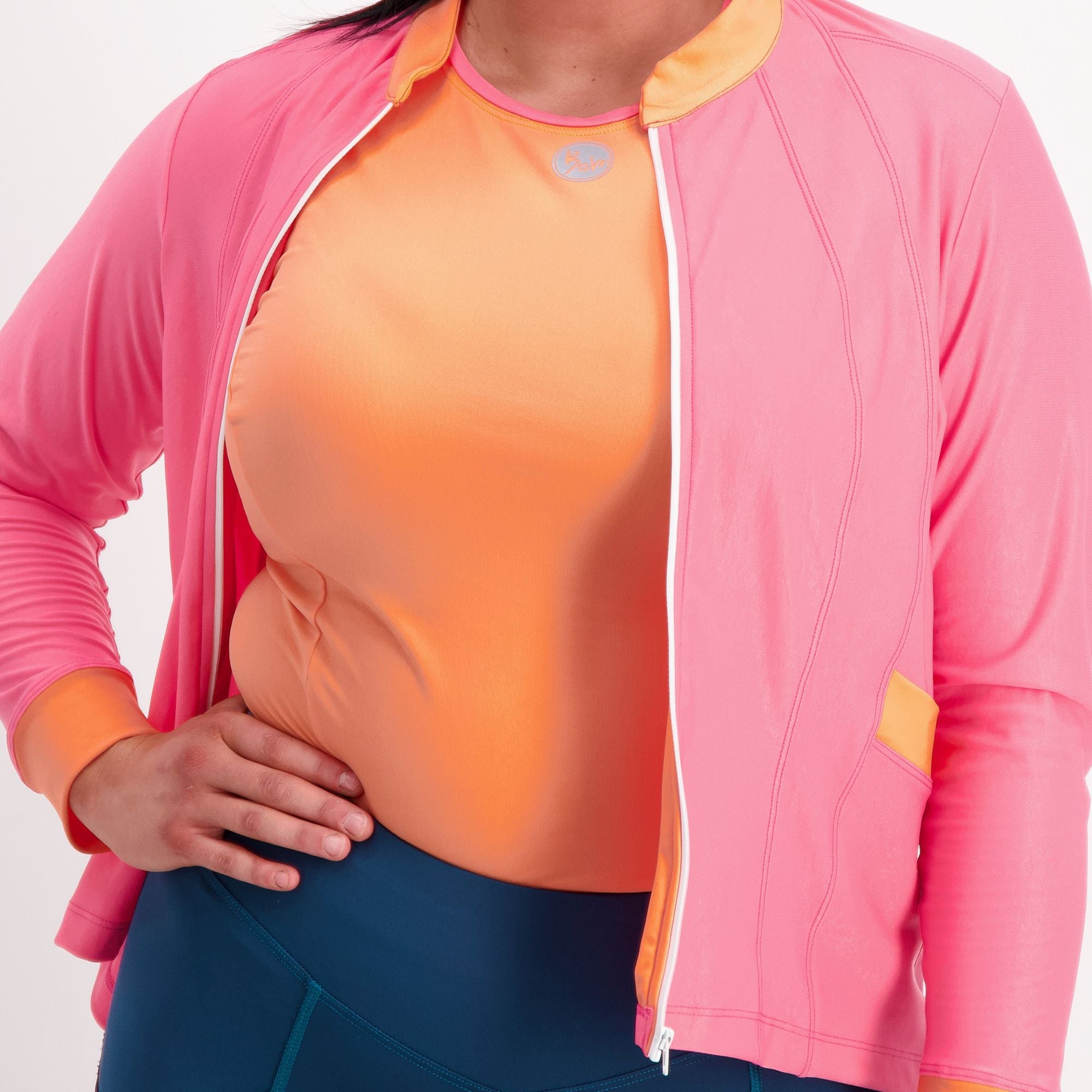 closeup of Orange with pink trim sleeveless Cycling Base Layer on female model with a pink jersey