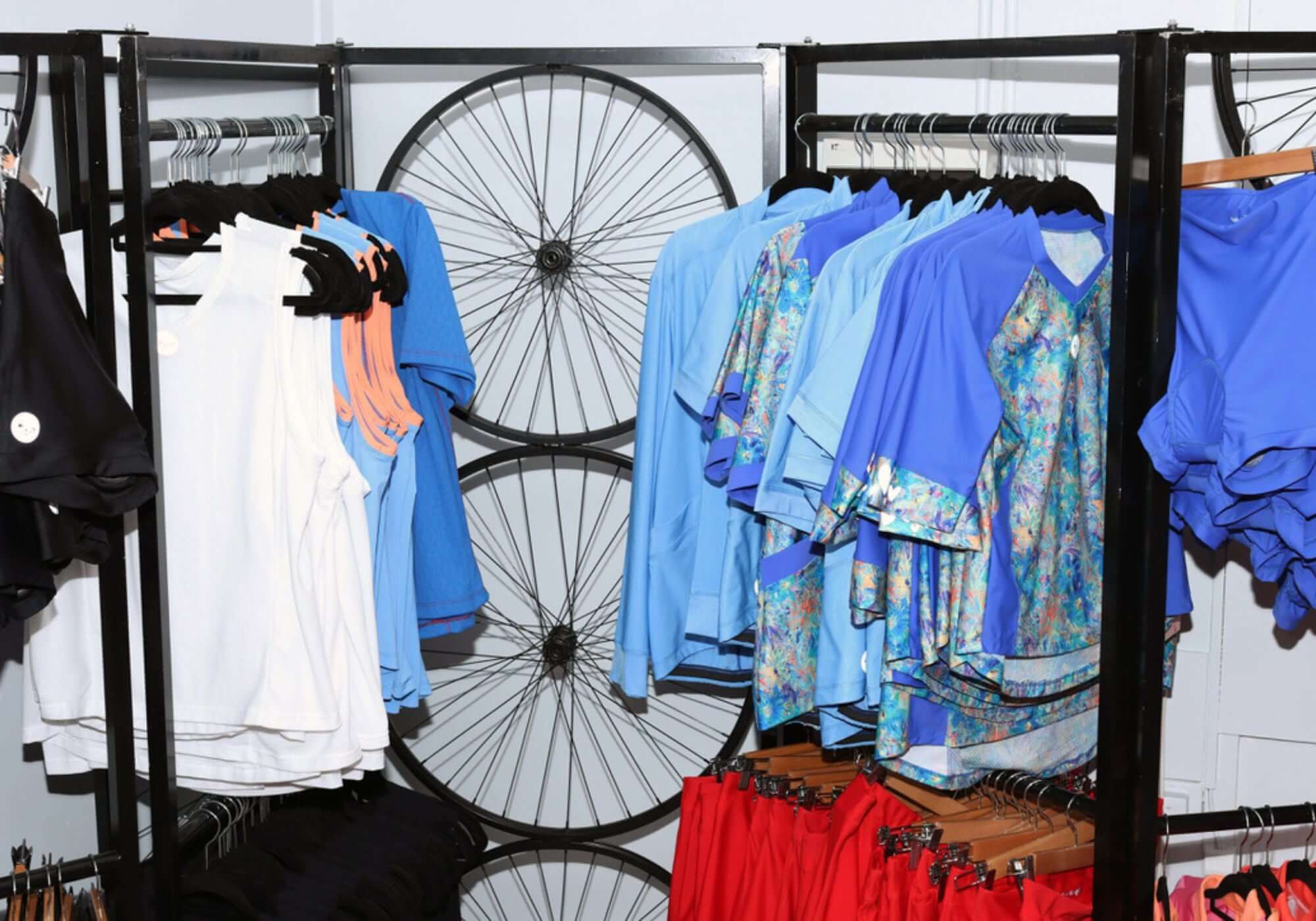 Clothing rack with various garments in front of a bicycle wheel