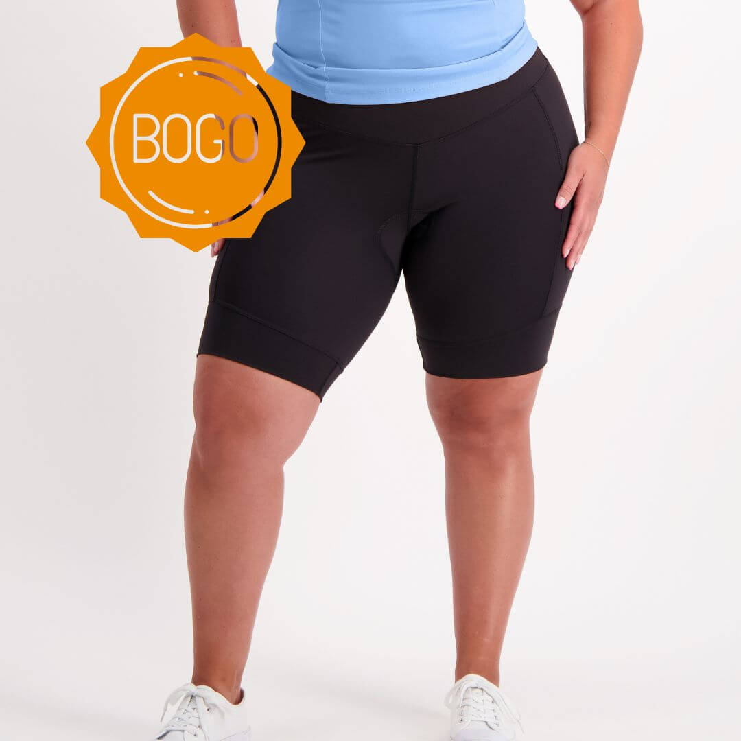 Person wearing black bicycle shorts padded with a BOGO badge on a white background