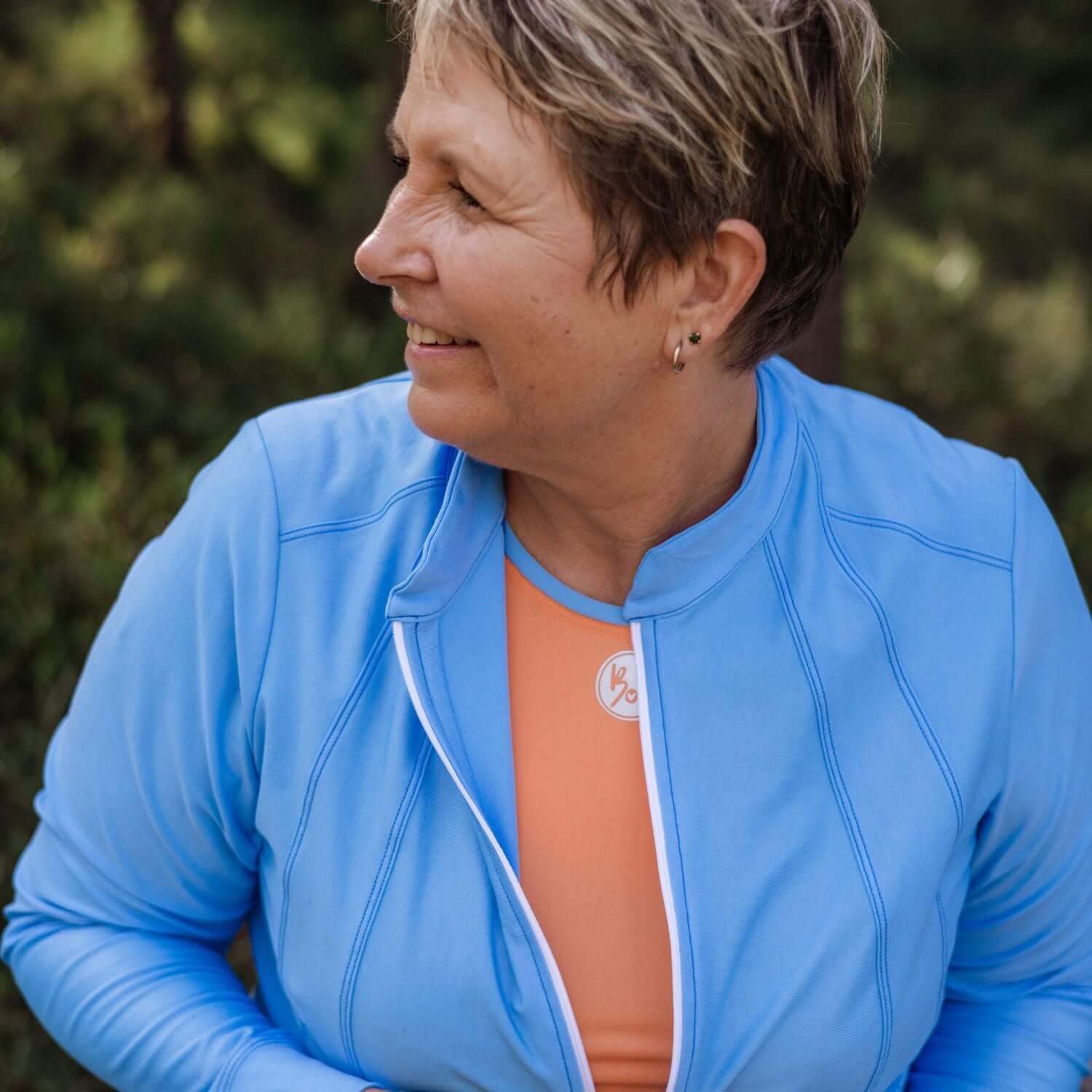 Woman wearing a blue jacket with a blurred natural background