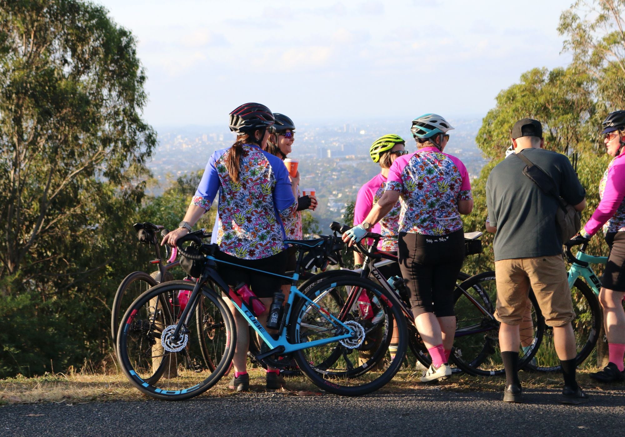 Group of cyclists taking a break with their bicycles in a scenic outdoor setting.