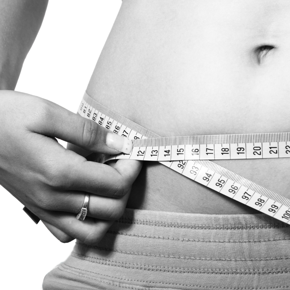 lady measuring waist with a tape measure