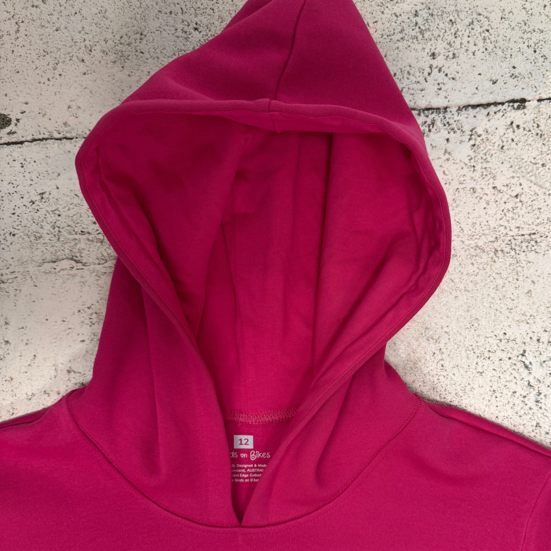 Close-up of the lined hood on the pink Outrider Hoodie, showing soft fleece and stitching detail