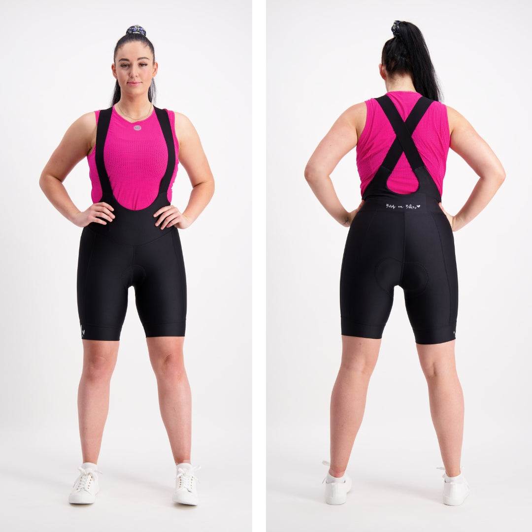 back and front view of female model in bright pink base layer and black cycling bib shorts