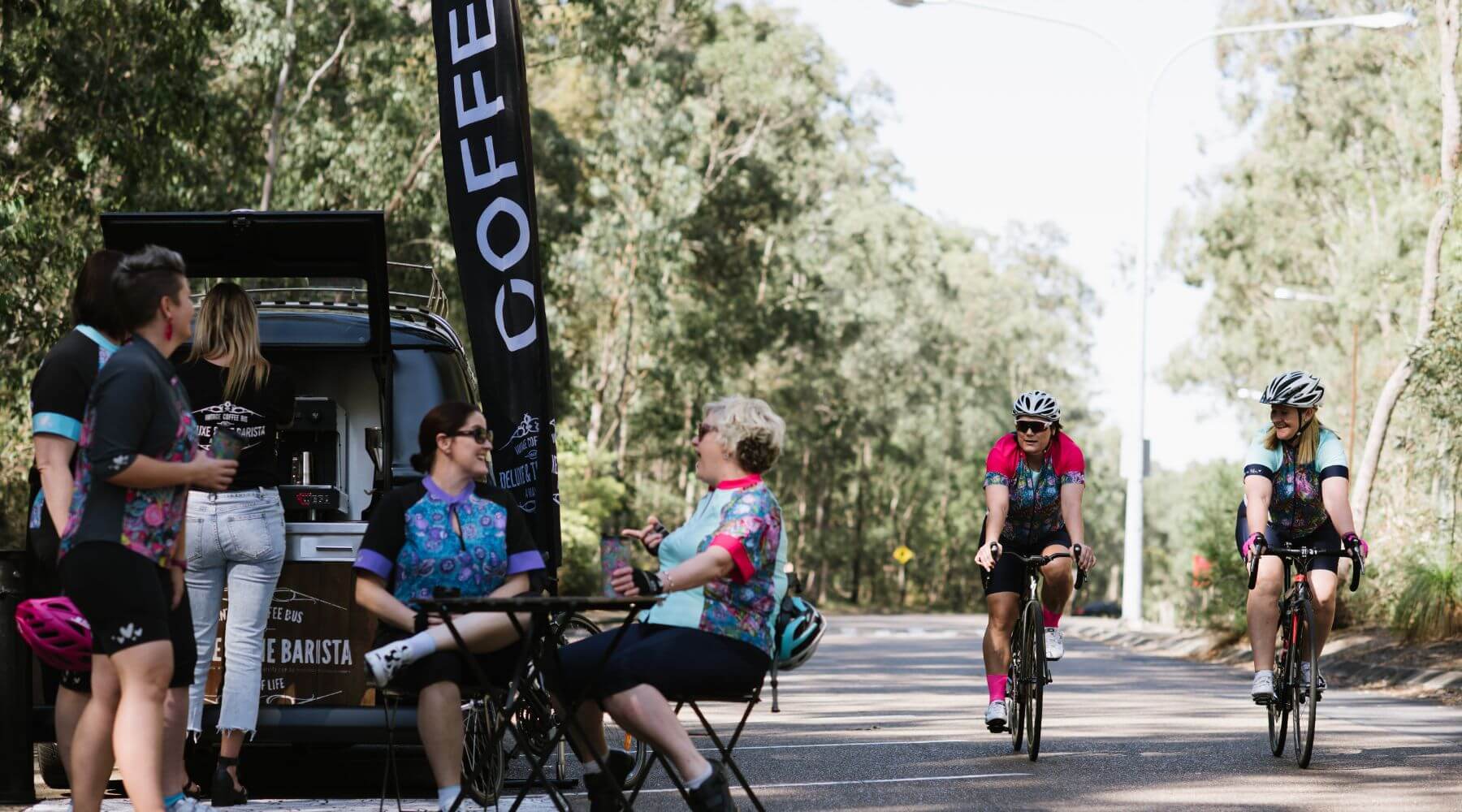 female cyclist in a blue jersey sitting at a coffee shop