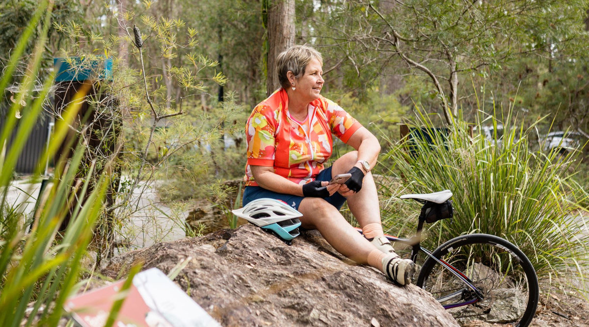 cyclists in colourful jersey sitting on a rock