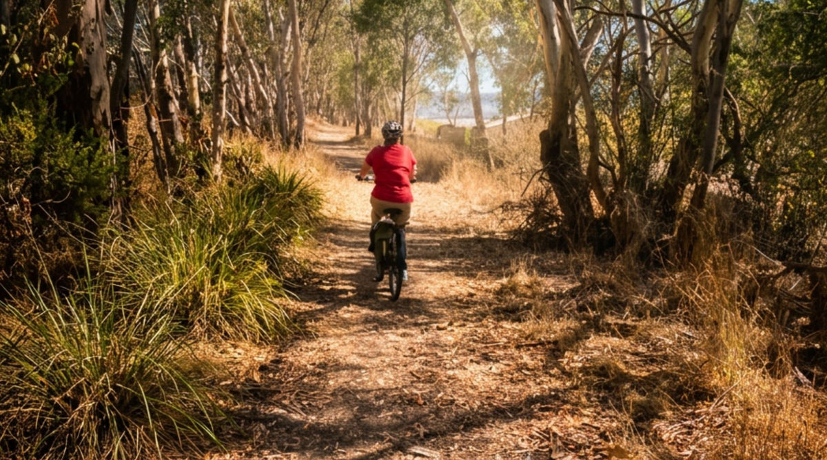cyclist in a red shirt riding a rail trail