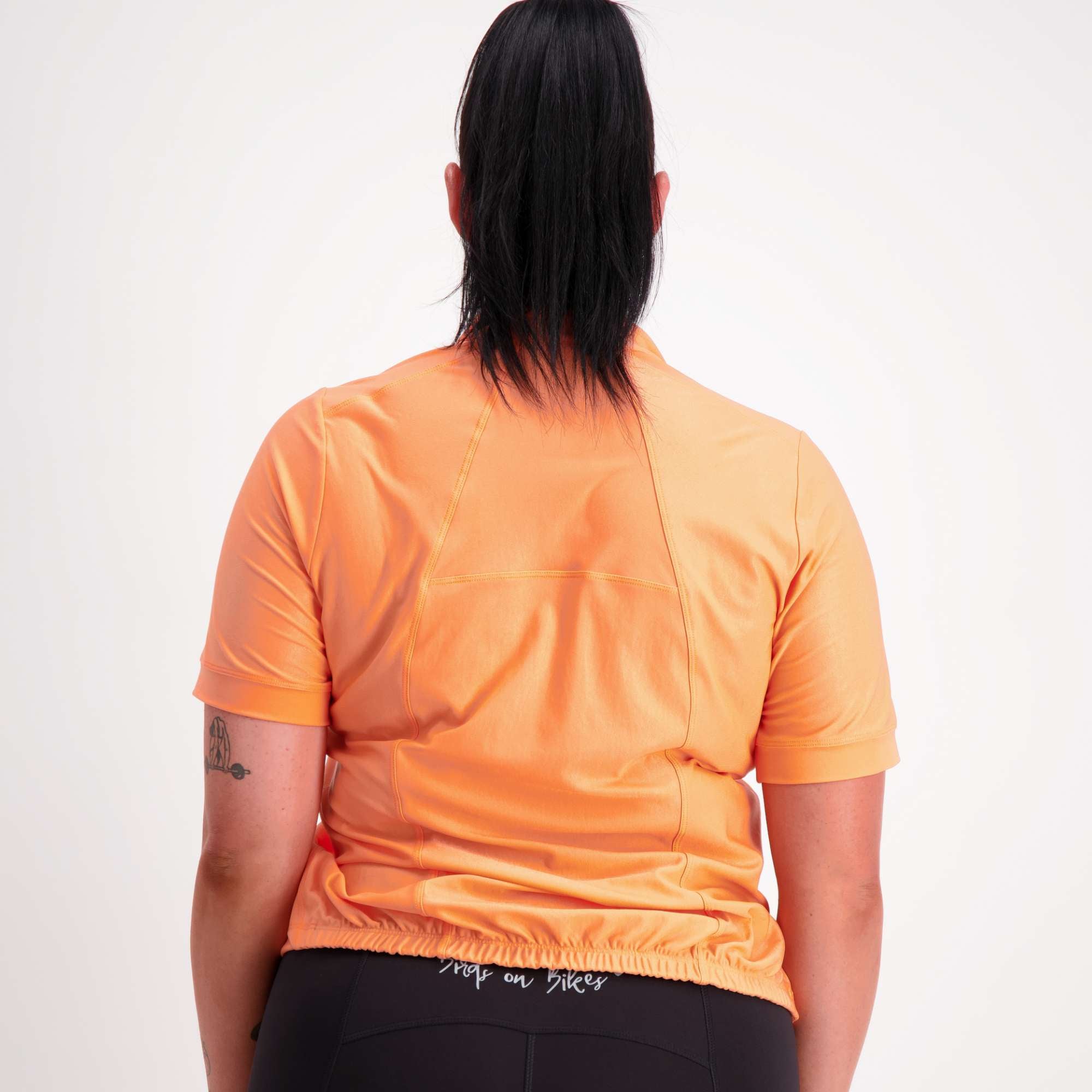 Orange short sleeve women's cycling jersey back view on model