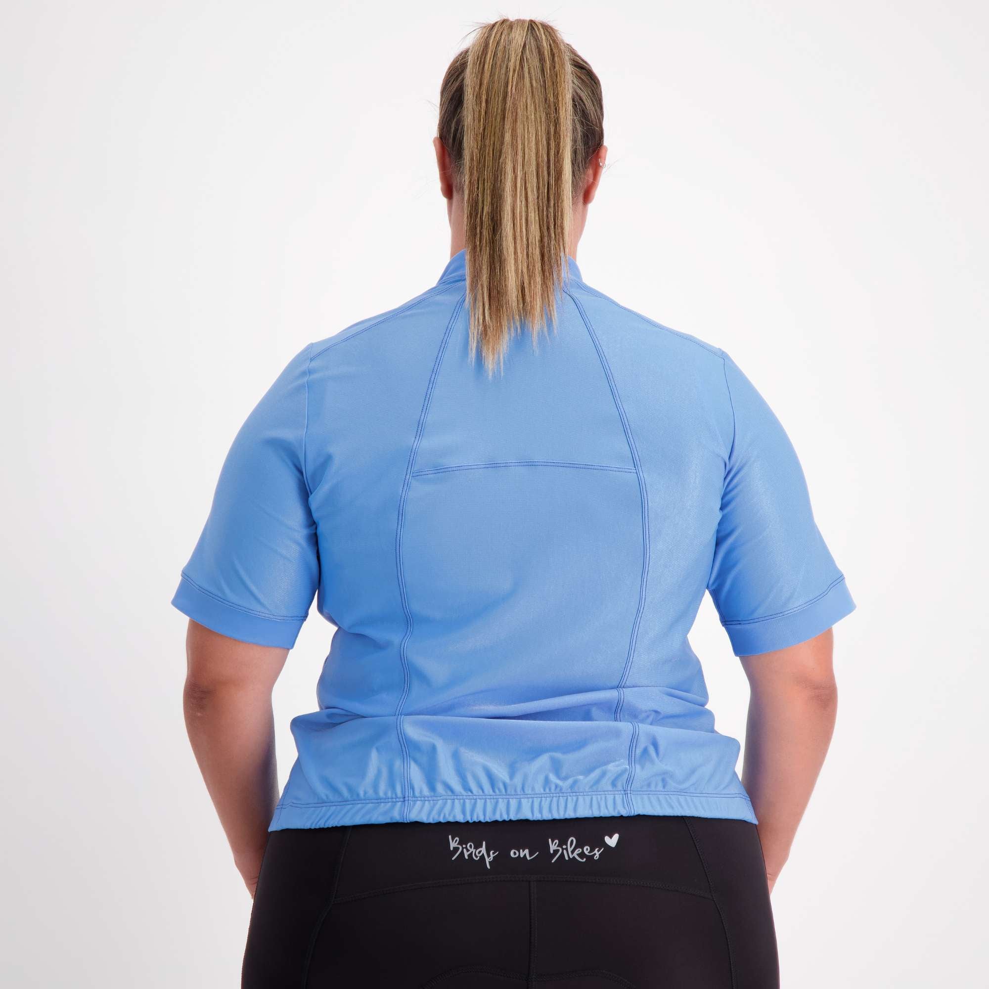 back view of female model dressed in blue short sleeve cycling jersey