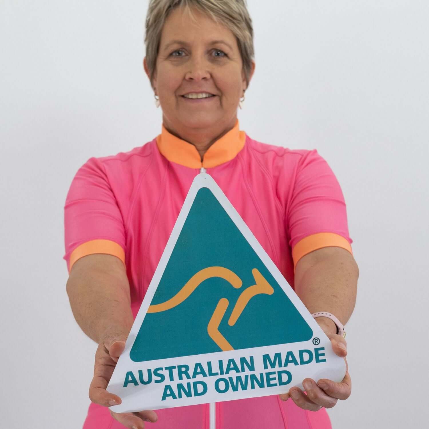 Person holding an 'Australian Made and Owned' sign against a plain background