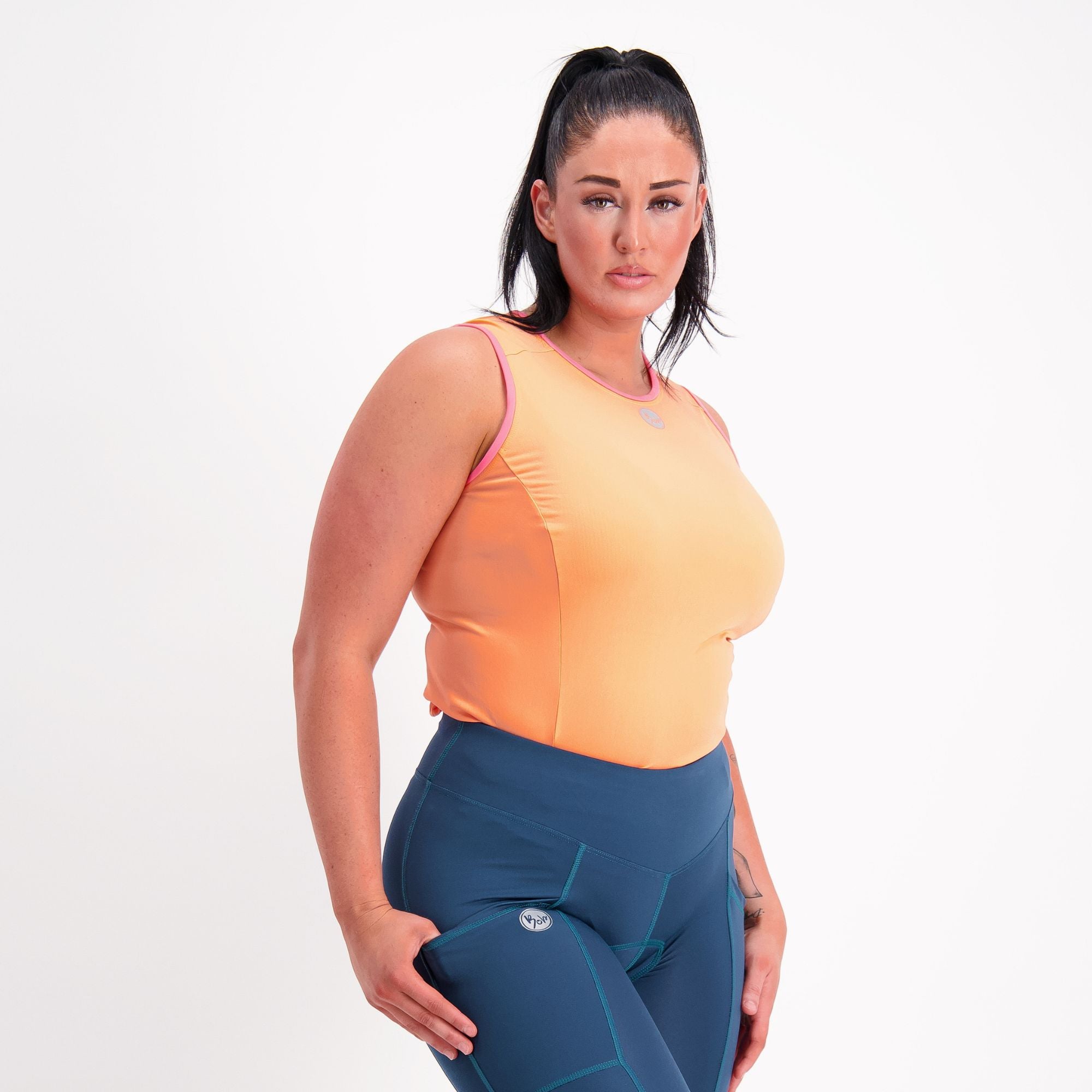 side front view of Orange with pink trim sleeveless Cycling Base Layer on female model