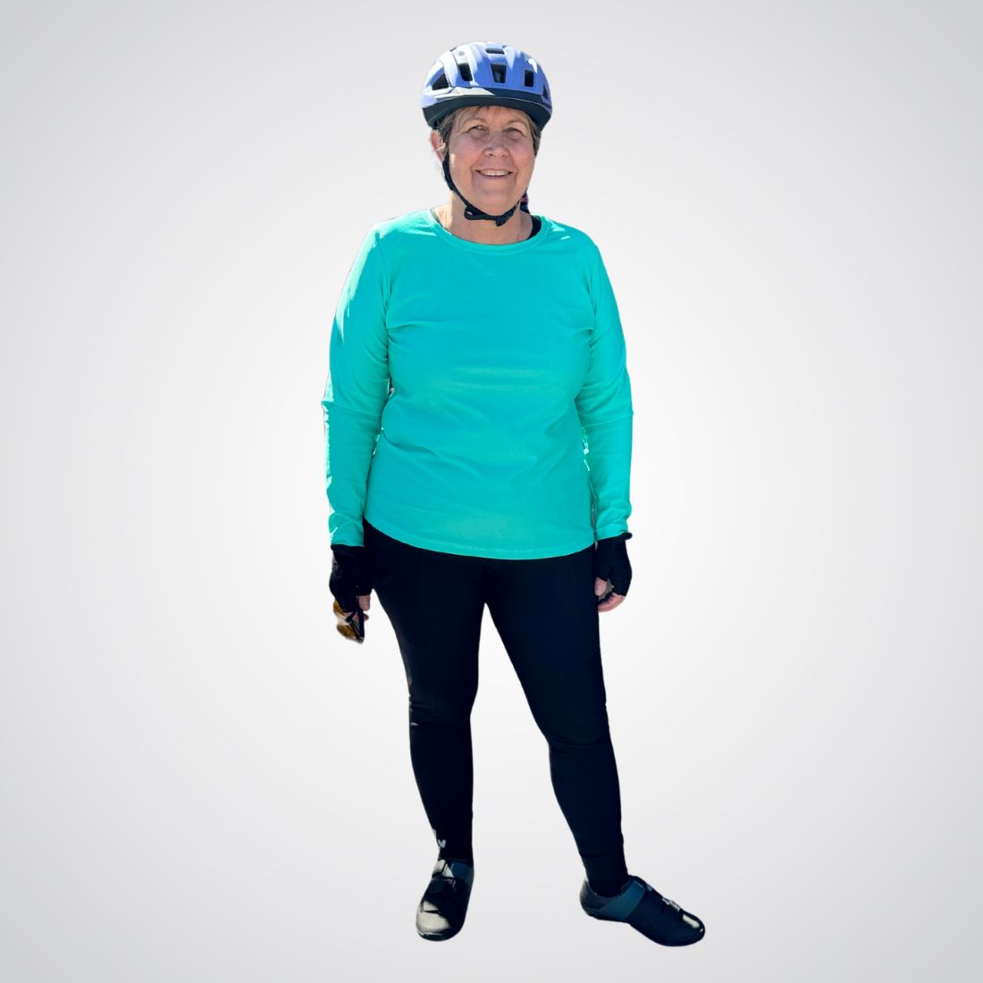 Person wearing a teal jacket and black pants with a helmet on a white background