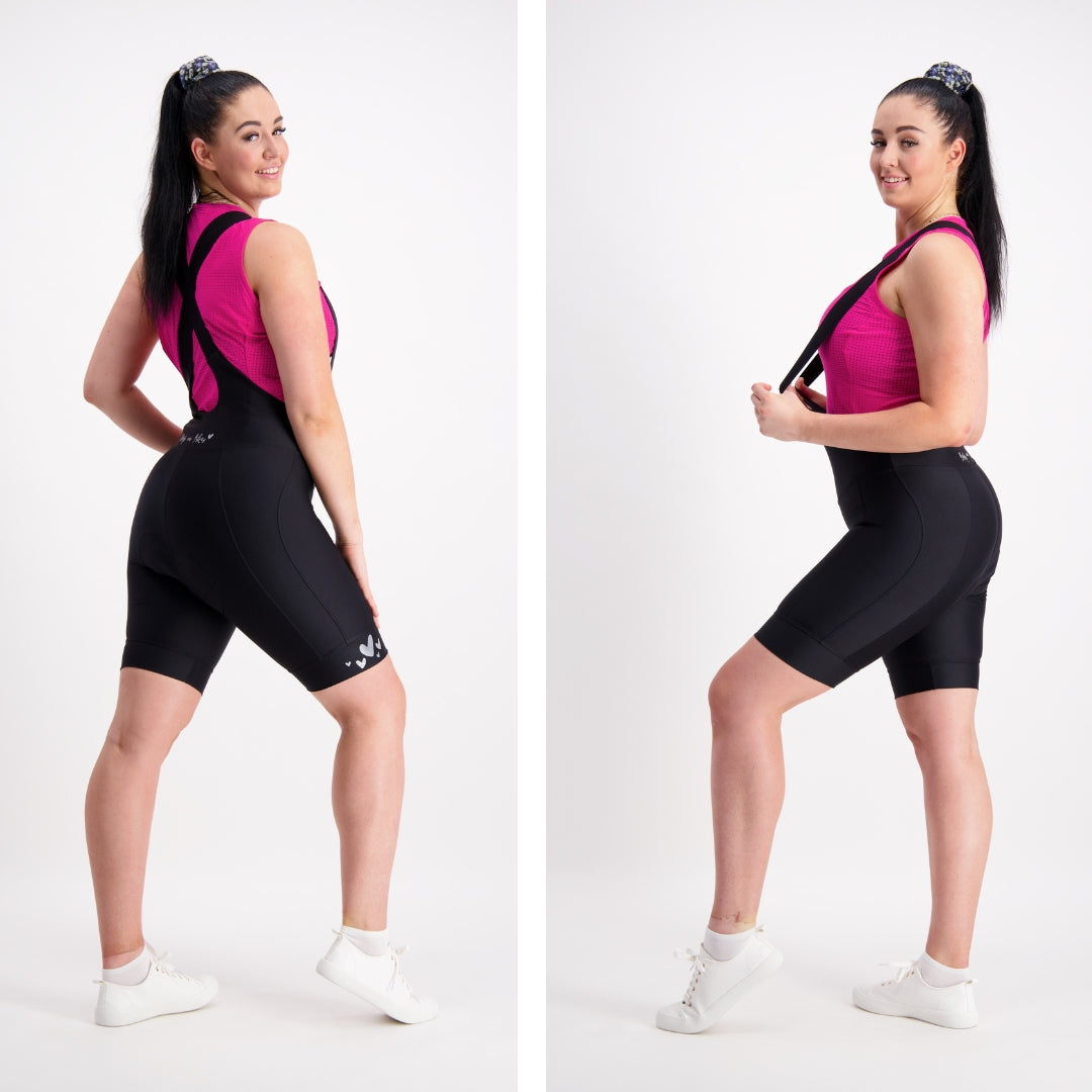 side views of female model in bright pink base layer and black cycling bib shorts